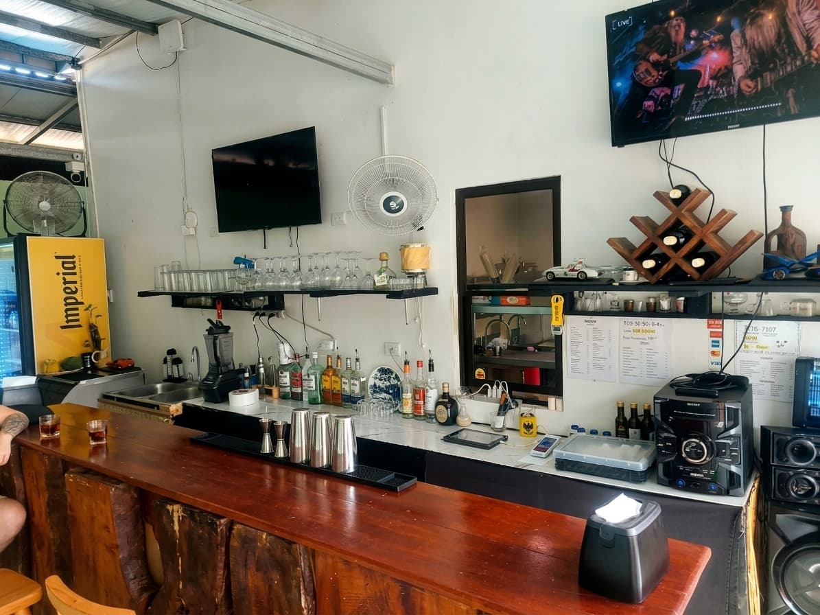 Barra de madera de La Fogata con botelleros y televisores