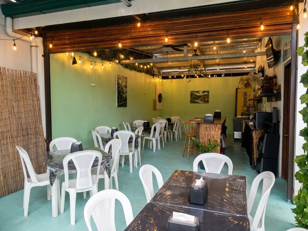 Comedor semiabierto de La Fogata en Playa Junquillal, con mesas, barra de caña y guirnaldas de luces cálidas