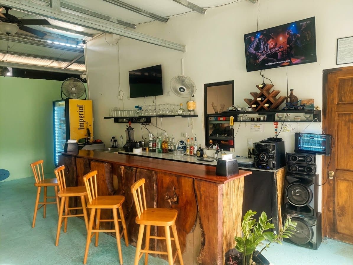 Interior del bar de La Fogata con sillas altas junto a la barra de madera